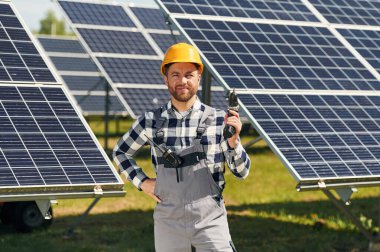 Elde matkap. Gündüz vakti fotovoltaik güneş panelleri olan bir mühendis..