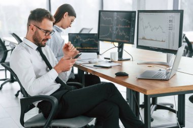 Bir projeye odaklanmış. İki çalışan ofiste birlikte çalışıyor..