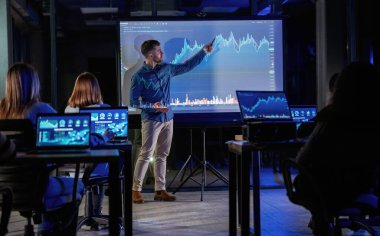 Akıllı koç. Erkek işletme eğitmeni projektöre karşı, insanlara öğretiyor..