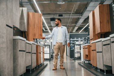 Mobilyalar ve dolaplar. Adam hırdavatçıda..