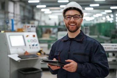 Tableti tutuyorum. Fabrika işçisi kasketli bir şekilde içeride..