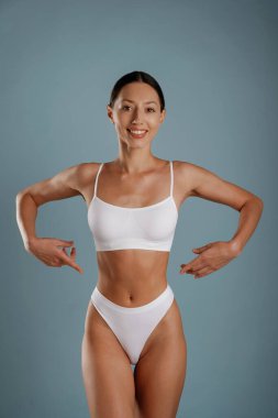 Fitness tipi ince vücut. Genç kadın stüdyoda arka planda..