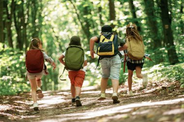 Sırt çantalı. Çocuklar yazın gündüz vakti ormanda..