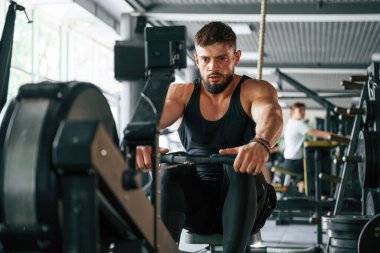 Dayanıklılık egzersizi. Güçlü kaslı adam spor salonunda çalışıyor..