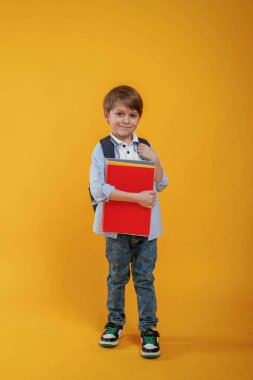 Küçük çocuk sarı arka planda stüdyoda..