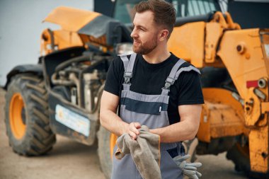 İş bittikten sonra elleri temizlemek, tamirci. Adam traktörle birlikte. Tarım işçisi.