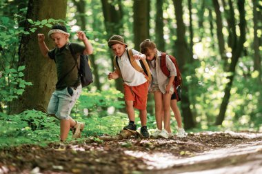 Patikaya doğru gidiyor. Çocuklar yazın gündüz vakti ormanda..