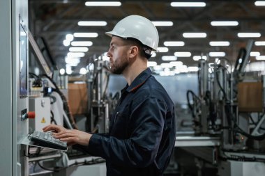 Ekipman kullanıyoruz, santral. Fabrika işçisi kasketli bir şekilde içeride..