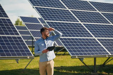 Dizüstü bilgisayarı tutuyorum. Gündüz vakti fotovoltaik güneş panelleri olan bir mühendis..