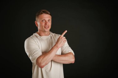 Yeni ürün, kopyalama alanında gösteriliyor. Adam stüdyoda arka plana karşı..