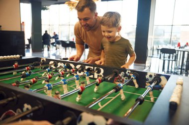 Eğlence anlayışı. Baba ve oğul içeride masa futbolu oynuyorlar..