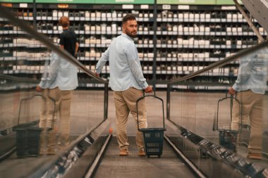 Müşteri gelmek üzeredir. Yakışıklı adam alışveriş merkezindeki yürüyen merdivende..