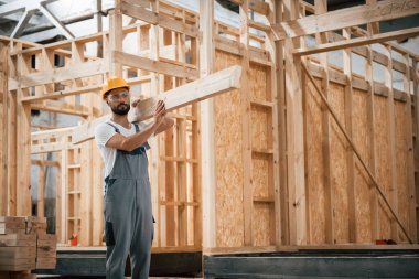 Tahtayı taşıyorum. Ahşap depoda sanayi işçisi..