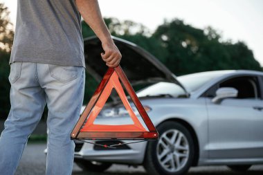 Kırmızı ışığı var, bozuk otomobil var. Adam dışarıda arabasıyla bekliyor..