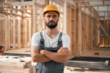 Kollarını kavuşturmuş bir portre. Ahşap depoda sanayi işçisi..