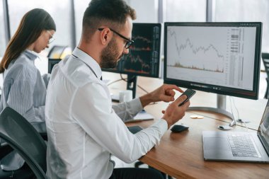 Bir projeye odaklanmış. İki çalışan ofiste birlikte çalışıyor..