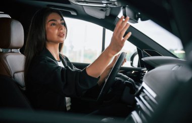 Yandan bak. Güzel iş kadını yeni arabasında..