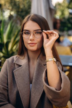 Gözlük takıyordu. Güzel genç bayan dışarıda..
