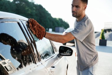 Nakliye aracı temizleniyor. Çamaşır servisi. Adam dışarıda arabasıyla bekliyor..