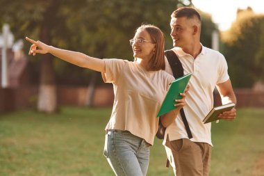 Parmaklarımla bir şey gösteriyorum. İki öğrenci dışarıda birlikteler..