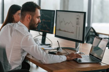 Bilgisayar monitörlerinden. İki çalışan ofiste birlikte çalışıyor..