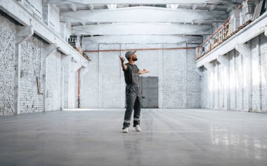 Büyük bir alan. Erkek işçi boş depoda..