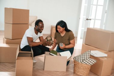 Mobilyaları kutudan boşaltıyorum. Afrikalı Amerikalı çift yeni eve taşınıyor..