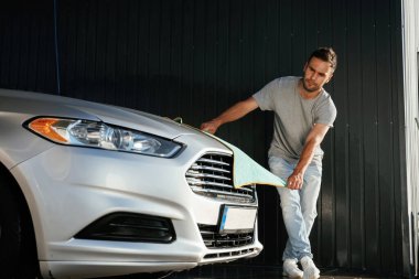 Kumaş, otomobili temizlemek. Adam dışarıda arabasıyla bekliyor..