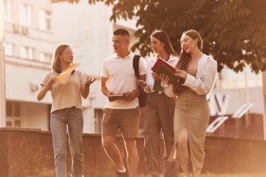 Güneş ışığıyla aydınlatılmış. Bir grup öğrenci birlikte dışarı çıktılar..