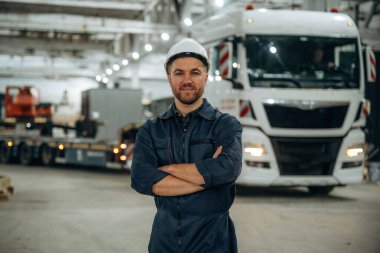 Bir kamyonun önünde duruyordum. Erkek işçi, modern depo veya imalat şirketinde çalışıyor..