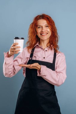 Beyaz kağıt bardakta taze içecek. Kadın stüdyoda arka planda..