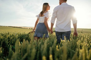 Arkadan bakın, el ele tutuşun, yürüyün. Güzel bir çift yeşil tarlada birlikte..