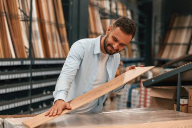 Büyük parke seçimi olan bir depo. Adam hırdavatçıda..