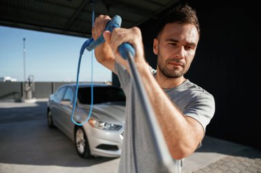 Otomobili yıkamaya hazırım. Adam dışarıda arabasıyla bekliyor..