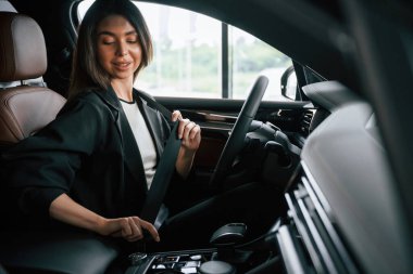 İçerisi rahattır. Güzel iş kadını yeni arabasında..