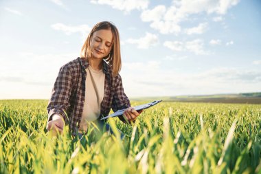 Bitkiye dokunmak. Gündüz vakti güzel tarla tarlasında genç bir kadın var..
