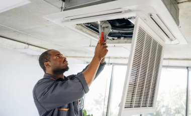 Havalandırma tavanda, tamir ediliyor. Tamirci modern ofiste kapalı bir yerde..