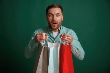 Şok olmuş yüz ifadesi. Adam stüdyoda arka planda duruyor..