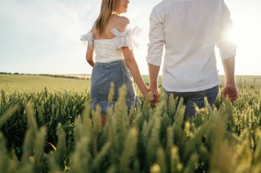 Arkadan bakın, el ele tutuşun, yürüyün. Güzel bir çift yeşil tarlada birlikte..