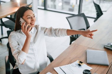 Telefonla konuşarak. İş kadını ofisin içinde..