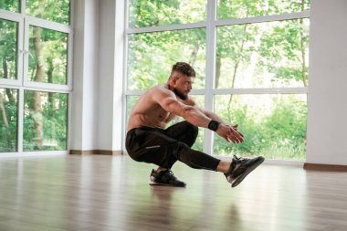 Yoga esneme hareketleri. Güçlü kaslı adam spor salonunda çalışıyor..