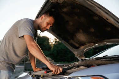 Kaput açıldı, tamir ediliyor. Adam dışarıda arabasıyla bekliyor..