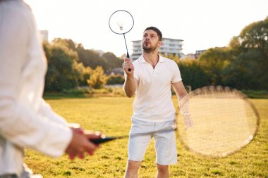 Spor ve hobi anlayışı. Kadın ve erkek sahada badminton oynuyorlar..