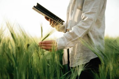 Dijital tablet hazır. Beyazlı kadın tarla tarlasında..