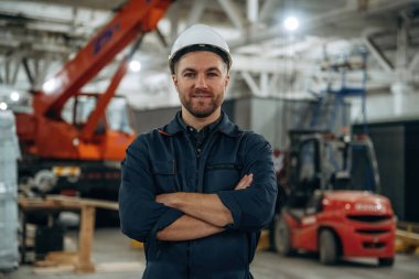 Ön manzara, ayakta. Erkek işçi, modern depo veya imalat şirketinde çalışıyor..