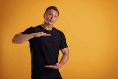 Görünmez afişi elinde tutuyor. Adam stüdyoda arka plana karşı..