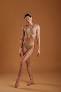 Güzel model. İnce vücutlu kadın arka planda poz veriyor..