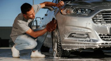 Oturup otomobili yıkıyorum. Adam dışarıda arabasıyla bekliyor..