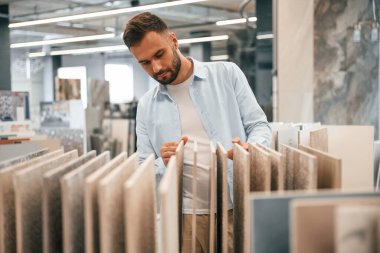 Banyo için krem renkli fayanslar. Adam hırdavatçıda..