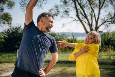 Happy, fitness egzersizi yapıyor. Doğada üst düzey çiftler birlikte..
